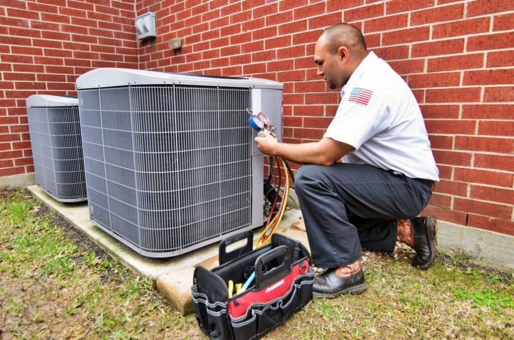 Technician testing an HVAC unit outside a brick home.