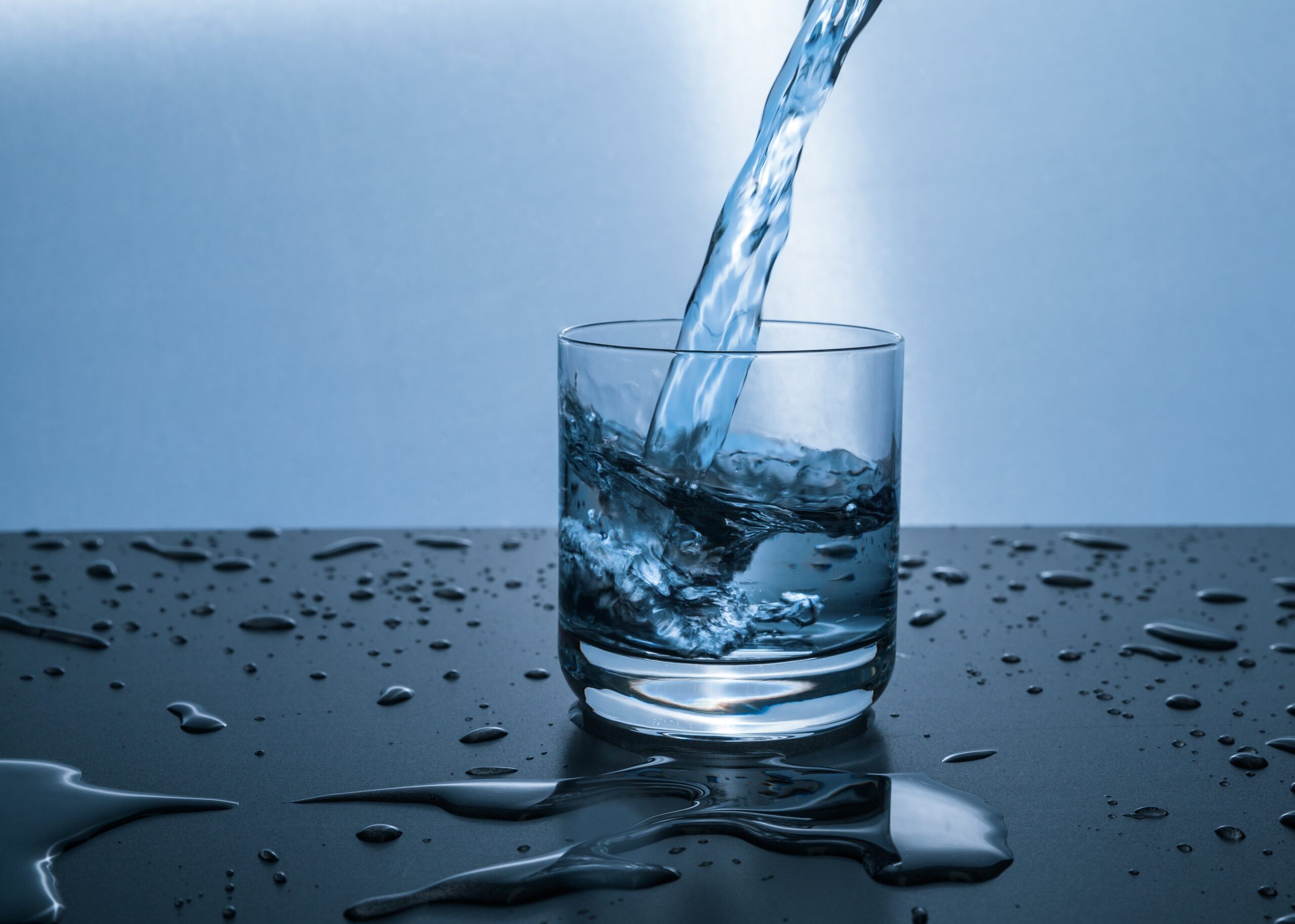 Drinking glass with water being poured into it.