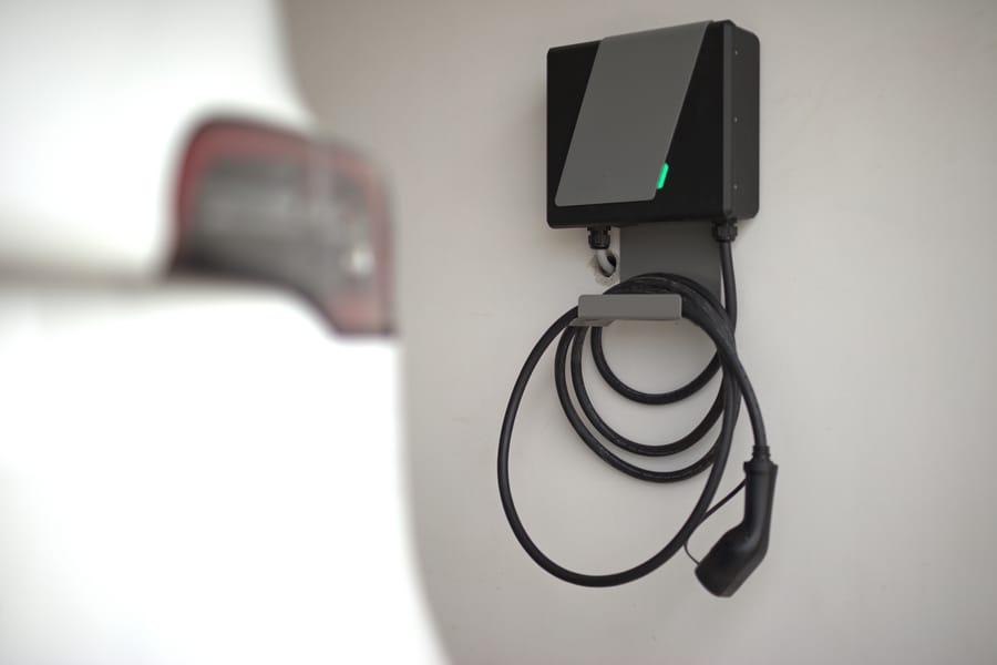 Electric car and electric car charger installed in the private garage at home.