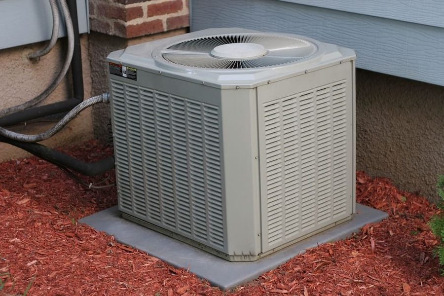 Outdoor air conditioning system on the side of a house on a concrete slab